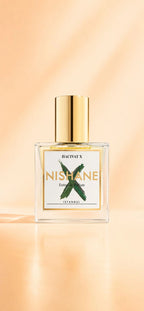 Frasco blanco y dorado del extracto de perfume Hacivat X de la marca nicho Nishane.